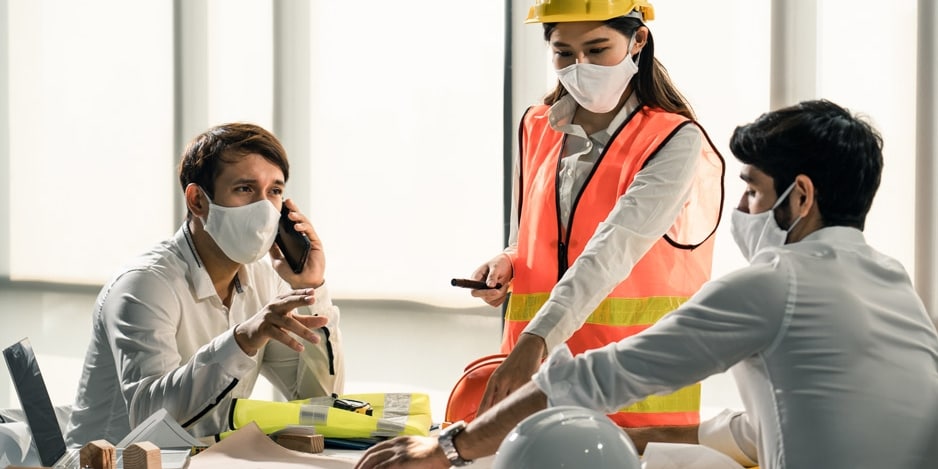 Group of building architect construction engineer have meeting and brainstorm together on table discussing about new project, teamwork talk with colleague. Members wear face mask prevent covid19 virus